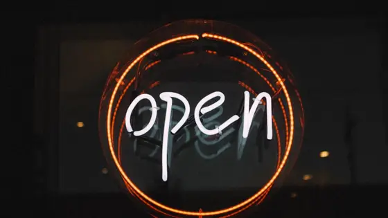 Vitrinde yanan turuncu neon 'open' tabelası